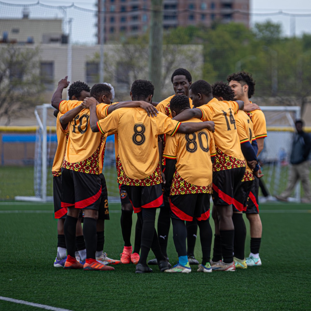 Uganda Cranes Ottawa FC team members gathering and cheering in a huddle